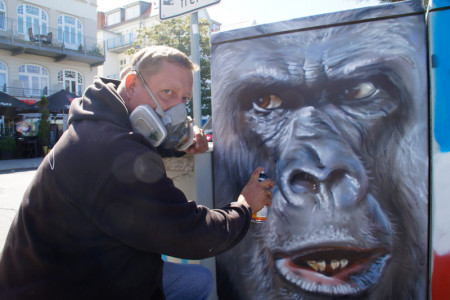 Diese Graffitisprüherei ist gewünscht und erlaubt: Sprayer Christian Hölzer in Warnemünde bei der Arbeit.