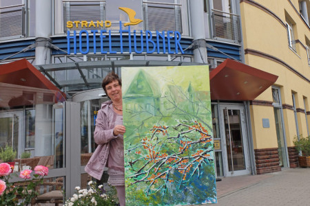 Die Künstlerin Hanna Hay mit ihrem Werk "Sanddorn in Grün".