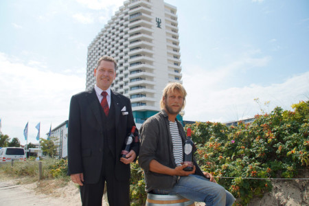 Nils Handke, F&B Manager im Warnemünder Hotel Neptun, und der Tres Hombres-Skipper Lammert Osinga (v.l.) bei der Übergabe des "Rostocker Rotspon".