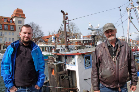 Alexander Kammerath (l.) und Fischer Eyke Düwel vor dem Kutter „Barth“. Ende April muss das Schiff raus aus dem Alten Strom sein.