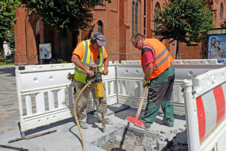 Die beiden Asa-Bau-Mitarbeiter Michael Kiefer und Sven Jens beim Öffnen der Pflasterung auf dem Kirchenplatz. 