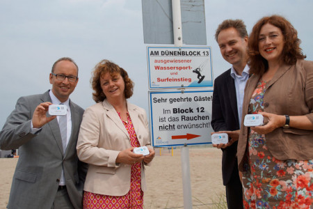 Matthias Fromm, Anett Bierholz, Holger Matthäus und Dr. Monika Griefahn präsentieren in Warnemünde "ihren" Strandascher.