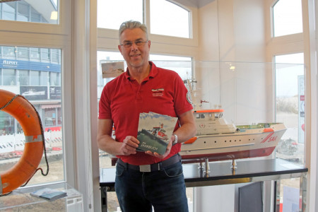 Der Leiter des Seenotretter Infozentrum in Warnemünde Jörg Westphal mit den aktuellen Jahrbüchern – seinem wichtigsten Werbemittel.