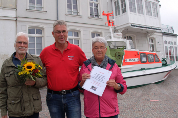 Der Leiter des Seenotretter-Infozentrum Warnemünde, Jörg Westphal, inmitten „seiner“ Jubiläumsgäste Erika und Günther Süßmilch aus Freiberg.