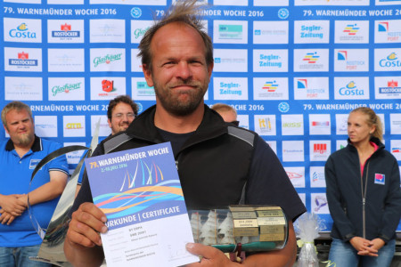Der sichtlich stolze Ospa-Skipper Oliver Schmidt-Rybrandt mit seinem Pokal für das beste Schiff mit Heimathafen Rostock.
