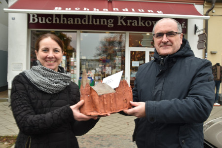 Buchhandlungschefin Sabine Sandig überreichte eine 535-Euro-Spende an Pastor Harry Moritz. Auch die Keramikkirche darf er mitnehmen.