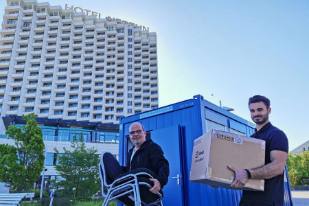 Frank Holle und Luca Legittimo von der Bürgertest Rostock GbR richten den neu abgestellten Testcontainer neben dem Hotel Neptun Warnemünde ein.