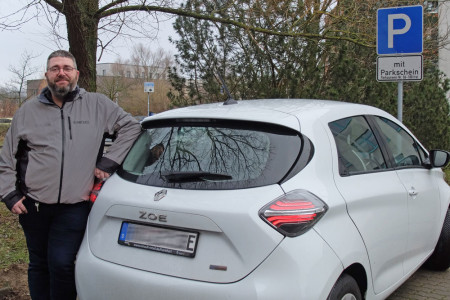 Noch fühlt sich Drehpunkt-Geschäftsführer Tino Korth mit seinem Elektroauto im Technologie Campus Warnemünde auf verlorenem Posten. Laden kann er seinen Wagen bislang hier nicht. Das soll sich ändern…