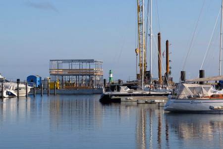 Es geht weiter: Mit einem halben Jahr Verzögerung haben jetzt die Bauarbeiten für das Sanitär- und Hafenmeisterhaus im neuen Warnemünder Sportboothafen begonnen.